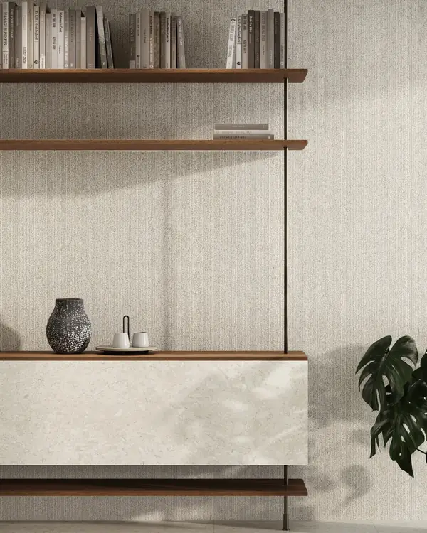 Nyra Utopia met licht grijsbeige wandreliëf achter houten planken en donkere staanders bij Atlas Concorde
