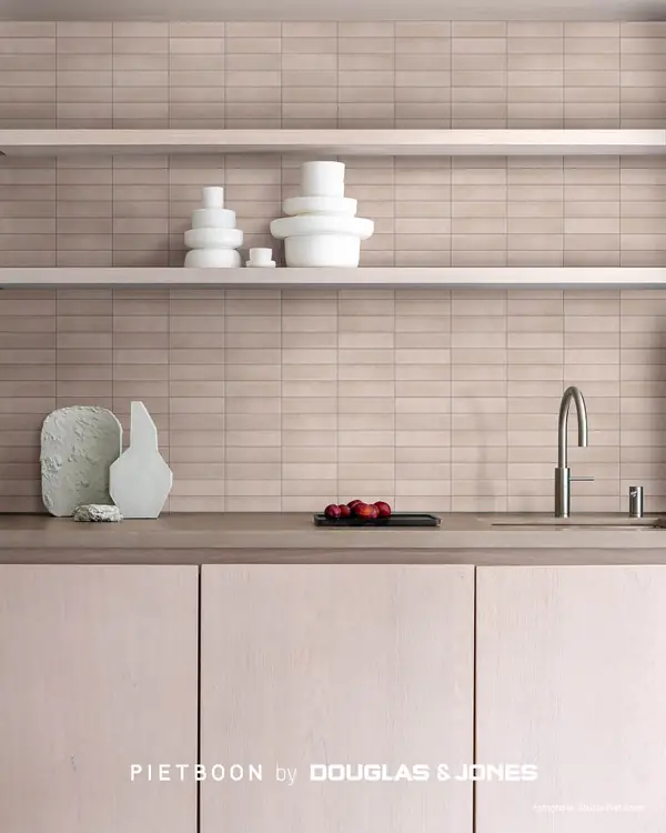 Keuken met zacht getinte COMPACT Tile-wandtegels, lichte houten fronten, open planken en wit servies.