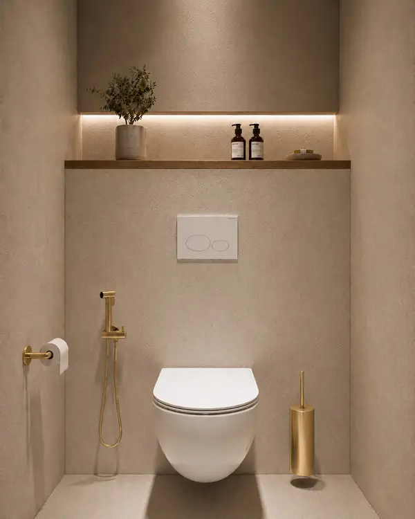 Bidetset met handdouche in messingkleur naast een wit wandcloset in een beige toiletopstelling bij Wiesbaden